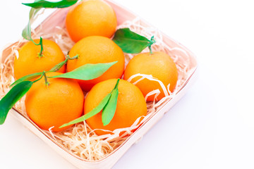 Tangerines with green leaves in a basket 