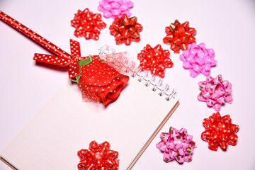 Valentines Day background. Red rose on  Blank notepad for copy space and ribbon satin bows on white blackground .  wedding day