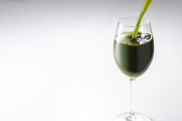 グラスに青汁を注ぎいれる