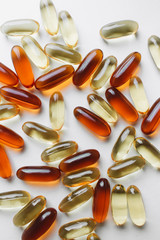 Pile of scattered capsules with medication on white background