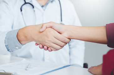 Confident Doctor shaking hands with patients talk in the hospital