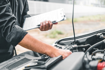Naklejka premium Auto mechanic working in garage Technician holding clipboard and check mechanic Maintenance car check.