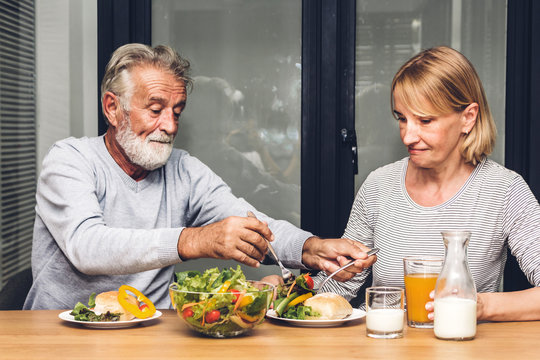 Senior Couple Enjoy Eating  Healthy Breakfast Together In The Kitchen.Retirement Couple Concept