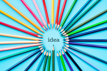Idea sharing concept, multicolored pencils on blue background