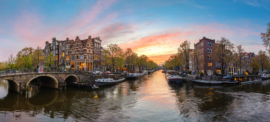 Obraz premium Amsterdam Netherlands, sunset panorama city skyline at canal waterfront