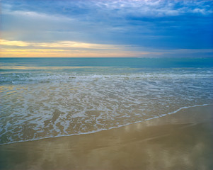 Dawn or dusk over a pastel colored seashore