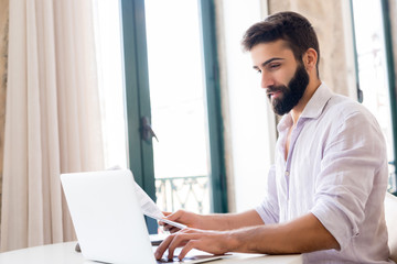 Fototapeta premium Man working on laptop from home