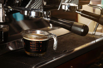 Fresh coffee in glass from professional coffee machine