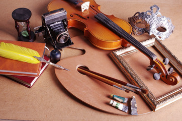 Attributes of art. Painting, music, theater, photography. Violin, art palette, mask, feather and inkwell, camera © yrafoto
