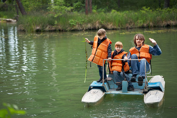 Man with two children is swimming on a pedal catamaran