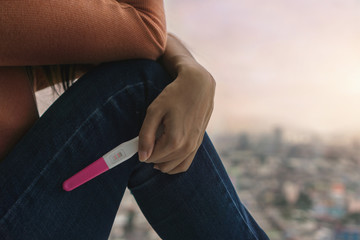 Unhappy young asian woman holding pregnancy test showing a positive result, Wellness and healthy...