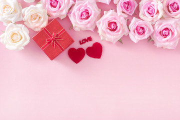 Valentine Day gift box with red hearts and roses on pink background