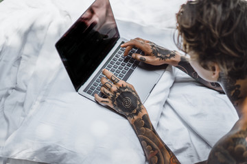 a man in bed working on a laptop, checking mail, watching a movie, listening to music, talking on...