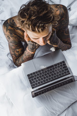 a man in bed working on a laptop, checking mail, watching a movie, listening to music, talking on...