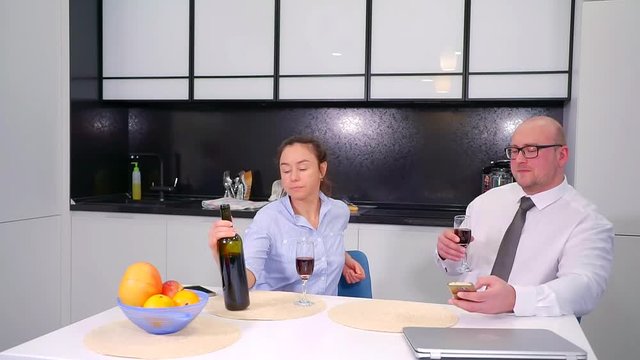 cute middle-aged couple celebrate the anniversary of the house in the kitchen drinking red wine. conversation between two adults after work at home