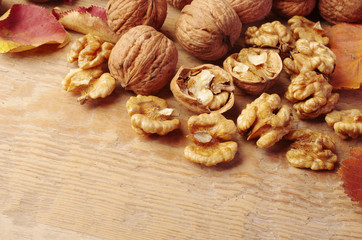 Walnut kernels, broken and whole nuts on a wooden table. 