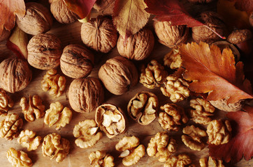 Walnut kernels, broken and whole nuts on a wooden table. 