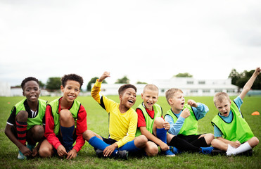 Enthusiastic football players sitting on the field