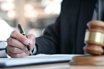Legal counsel presents to the client a signed contract with gavel and legal law. justice and lawyer...
