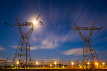 high-voltage power lines and high voltage electric transmission tower in the light of the full moon