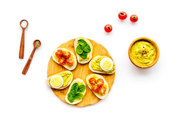 Healthy snacks. Set of toasts with vegetables like avocado, guacamole, rocket, cherry tomatoes on white background top view
