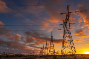 high-voltage power lines at sunset. electricity distribution station