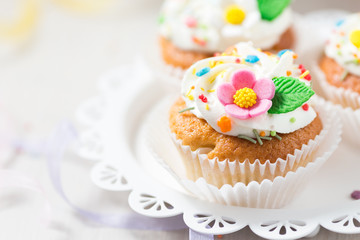Easter cupcakes with white cream and sugar flowers