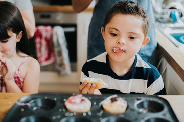 Brother and sister tasting fresh cupcakes