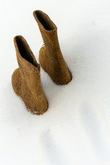 traditional winter shoes felt boots on white snow