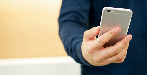 close up hand hold mobile cell phone device:focus on man play on smartphone concept.