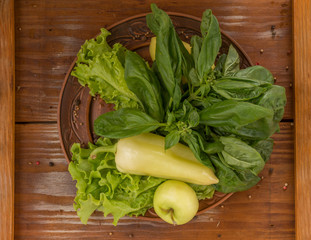 Green pepper with green salad, apple and basil on the plate placed on the rustic vintage wooden background - 244457871