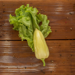 Green pepper with green salad, apple and basil on the plate placed on the rustic vintage wooden background - 244457888