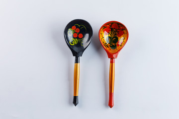Two wooden spoons with a traditional Russian pattern on a white background. Khokhloma painting.