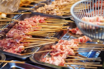 Raw meat beef pork chicken Sausage in wooden stick - street food.