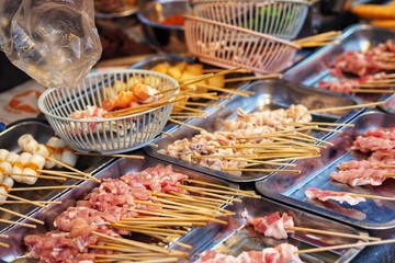 Raw meat beef pork chicken Sausage in wooden stick - street food.