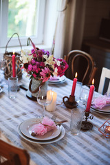 romantic summer dinner in cozy country house. Festive table setting with flowers and candles in purple tones
