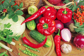 Vegetables on a wooden table. Cabbage, pepper, tomato, cucumber, onion