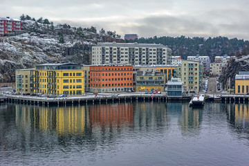 Naklejka premium New residential apartment blocks sit on a hillside near the waterfront of Baltic sea bay in the Kvarnholmen district of Stockholm, Sweden.