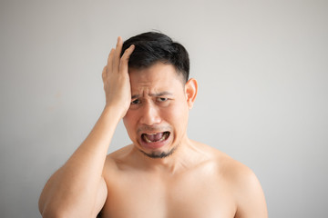 Cry and sad face of Asian man in topless portrait isolated on gray background.