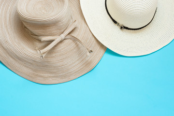 Various broad brimmed women's straw hats on light mint blue background. Summer vacation fashion...