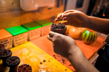 Shisha hookah preparing by barman. Bartender lays tobacco for smoking