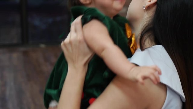 Attractive mother giving her crying toddler baby girl a hug and embrace her with love