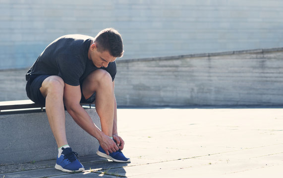 Young and sporty man training outdoor in sportswear. Sport, health, athletics.