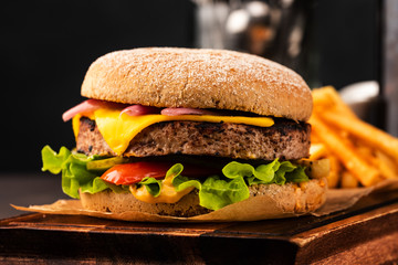 Delicious fresh homemade cheeseburger with marinated onions and red pepper. Beef Burger with Cheese and Vegetables.