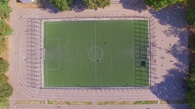 Aerial topside down view of football field with amateur football players