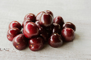 red sweet cherry on a light wooden background 