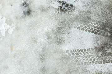 Boot print and tyre track on a snow