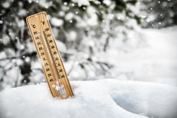 thermometer with sub-zero temperatures sticking out of the snow