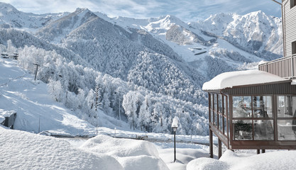 Winter view of the balcony of the house and the ski slope