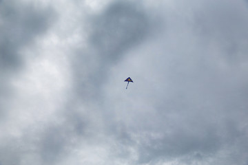 Blue kite on the background of gloomy clouds